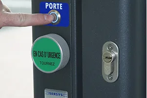 Montant de porte équipé d'une commande d'ouverture et d'un dispositif d'urgence SERSYS